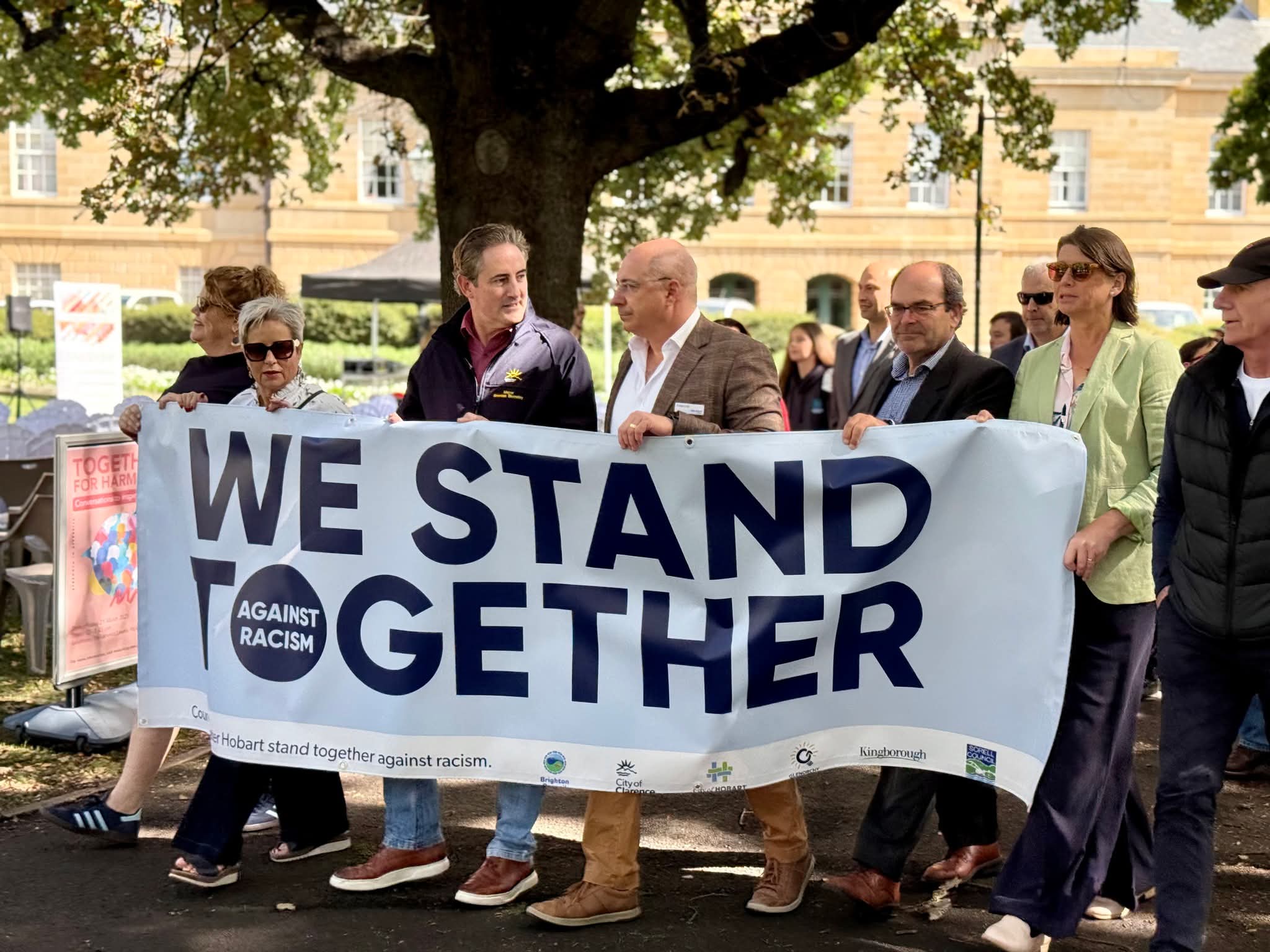 Aldo holding We Stand Together Against Racism banner